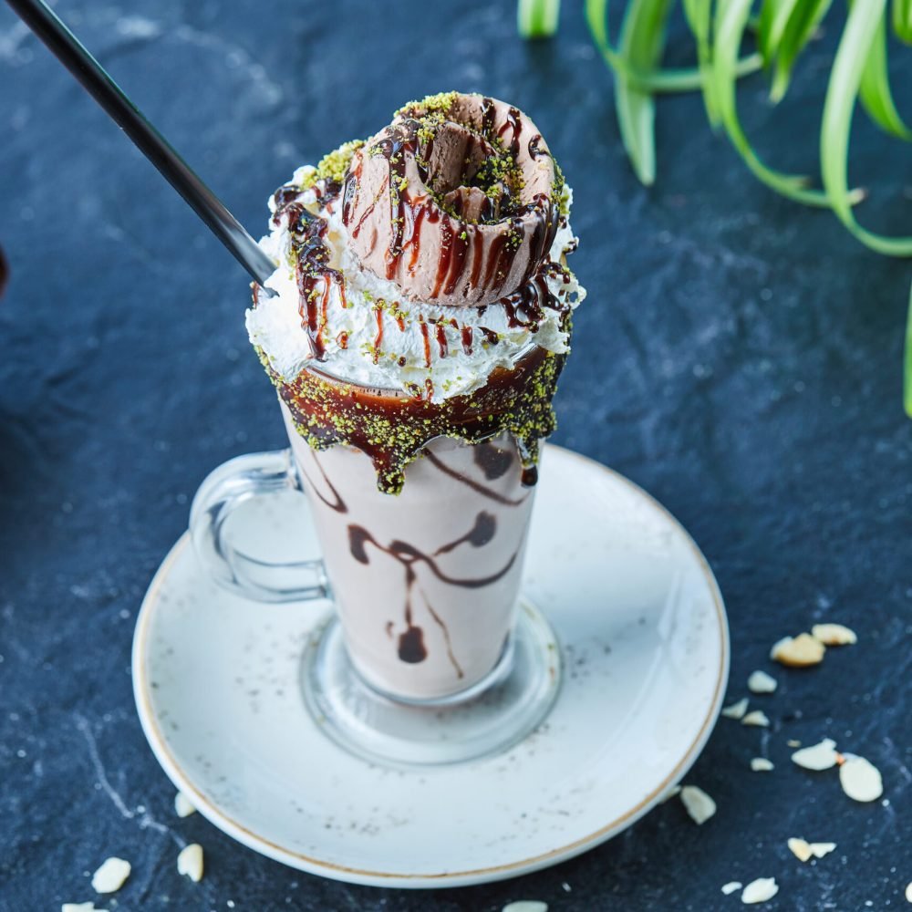 Milkshake with cone, chocolate , sprinkles and in the dark background
